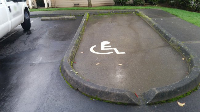 Drole de parking pour handicapes... encercle par un muret