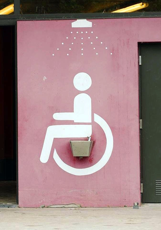 Signe Fauteuil roulant au mur qui peint les fesses au dessus d'un lavabo